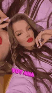 a woman with red lipstick is laying next to another woman with the name votana on her arm