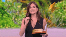 a woman in a black dress is holding a trophy that says ' extra duro ' on it .
