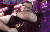 a man wearing glasses and a shirt that says ale is covering his mouth