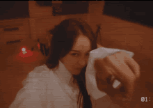 a woman in a white shirt is taking a selfie with the number 01 on the bottom left