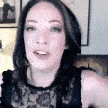 a close up of a woman 's face with a black lace top on