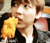 a close up of a person eating a fried food with a foreign language written on the bottom
