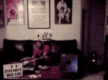 a man sits on a couch with a sign that says streamys mar 3rd