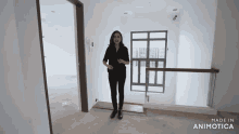 a woman is standing in a room with the words made in animatica on the bottom right