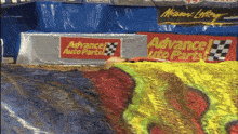 a man is laying in the dirt next to a sign for advance auto parts