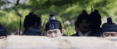a group of men wearing traditional korean hats are standing in a row .