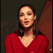 a woman in a red sweater is making a gesture with her hands