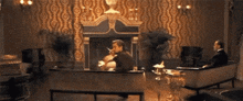 a man sitting in front of a fireplace smoking a cigar