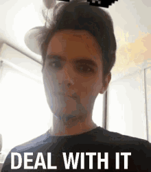 a man in a black shirt is making a funny face with the words `` deal with it '' written on the bottom .