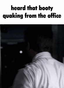 a man 's back is shown with the words heard that booty quaking from the office above him