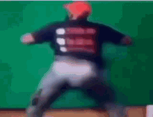 a blurry picture of a person dancing in front of a green background .