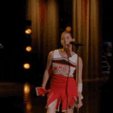 a cheerleader from wmhs is singing into a microphone on a stage