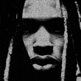 a close up of a person 's face with dreadlocks and red eyes .