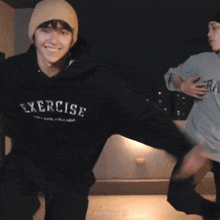 a person wearing a beanie and a sweatshirt that says ercis is smiling at the camera .