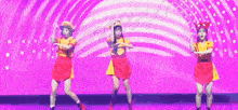three girls are dancing on a stage with a purple background .
