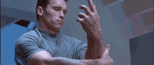 a man is holding a drill in his hand and cutting his arm .