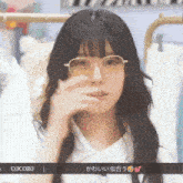 a woman wearing glasses and a white shirt has the word cocoro on the bottom right