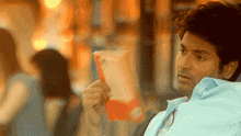 a man in a blue shirt is holding a bag of chips in his hand