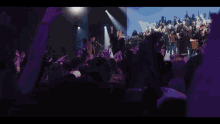 a woman singing into a microphone in front of a crowd of people