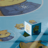 a cube with a picture of a cat on it sits on a blue surface