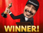a man wearing a hat that says multivers is holding an oscar statue
