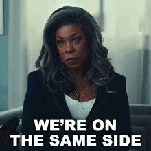 a woman sitting in a chair with the words we 're on the same side behind her