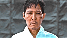 a man with a beard and a white shirt has a serious look on his face