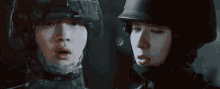 a man and a woman are wearing military helmets and looking at each other