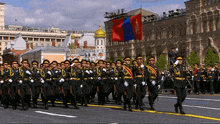 a group of soldiers marching down a street with a flag that says ' russian federation ' on it