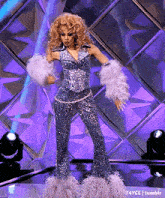 a woman in a sequined outfit with feathered cuffs is dancing on a stage ..