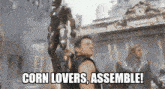 a man standing in front of a statue with the words corn lovers assemble