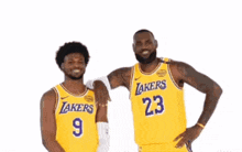 two basketball players for the lakers are standing next to each other and hugging