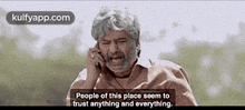 a man is talking on a cell phone and says `` people of this place seem to trust anything and everything . ''