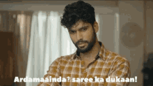 a man in a plaid shirt says " ardamainda "
