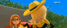 a woman in a yellow hat is talking to another woman