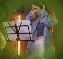 a woman is wearing a white tank top with black bows on it and a necklace .