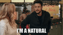 a man and a woman are standing next to each other and the man is saying i 'm a natural