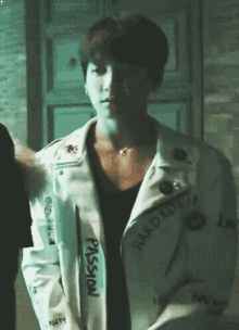 a young man wearing a white leather jacket with the word passion on it