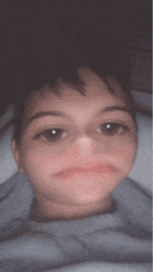 a close up of a person 's face with a gray sweater on