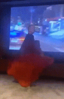 a blurred image of a person sitting in front of a television screen