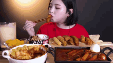 a woman in a red shirt is eating some food