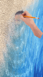 a hand is holding a pencil and drawing a picture of a person in the water