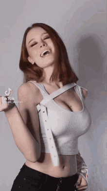a woman is wearing a white crop top with a white belt around her neck