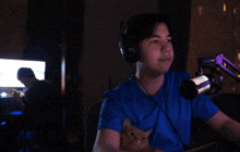 a man wearing headphones is holding a cat in his lap in front of a microphone