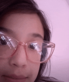 a close up of a person wearing glasses with a pink frame
