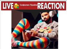 a man wearing rainbow striped socks is playing a video game under a live reaction banner