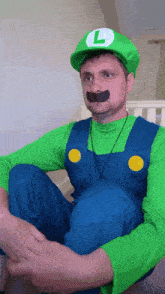 a man in a luigi costume with a l on the hat