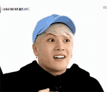 a young man wearing a blue hat and a black hoodie is smiling .