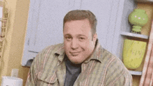 a man in a costume is sitting in front of a mirror and smiling .