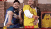 a man in a yellow shirt is standing next to another man in a blue shirt with jvc on it